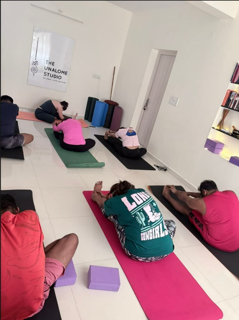 Group yoga class at The Unalome Studio — students in a shared practice